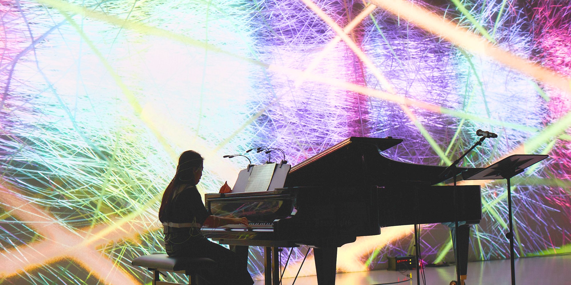 Maki Namekawa playing the piano in Deep Space wearing the Life Ink wearables