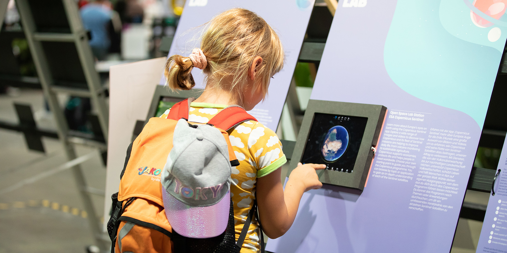 child in front of a tousch screen showing planet earth